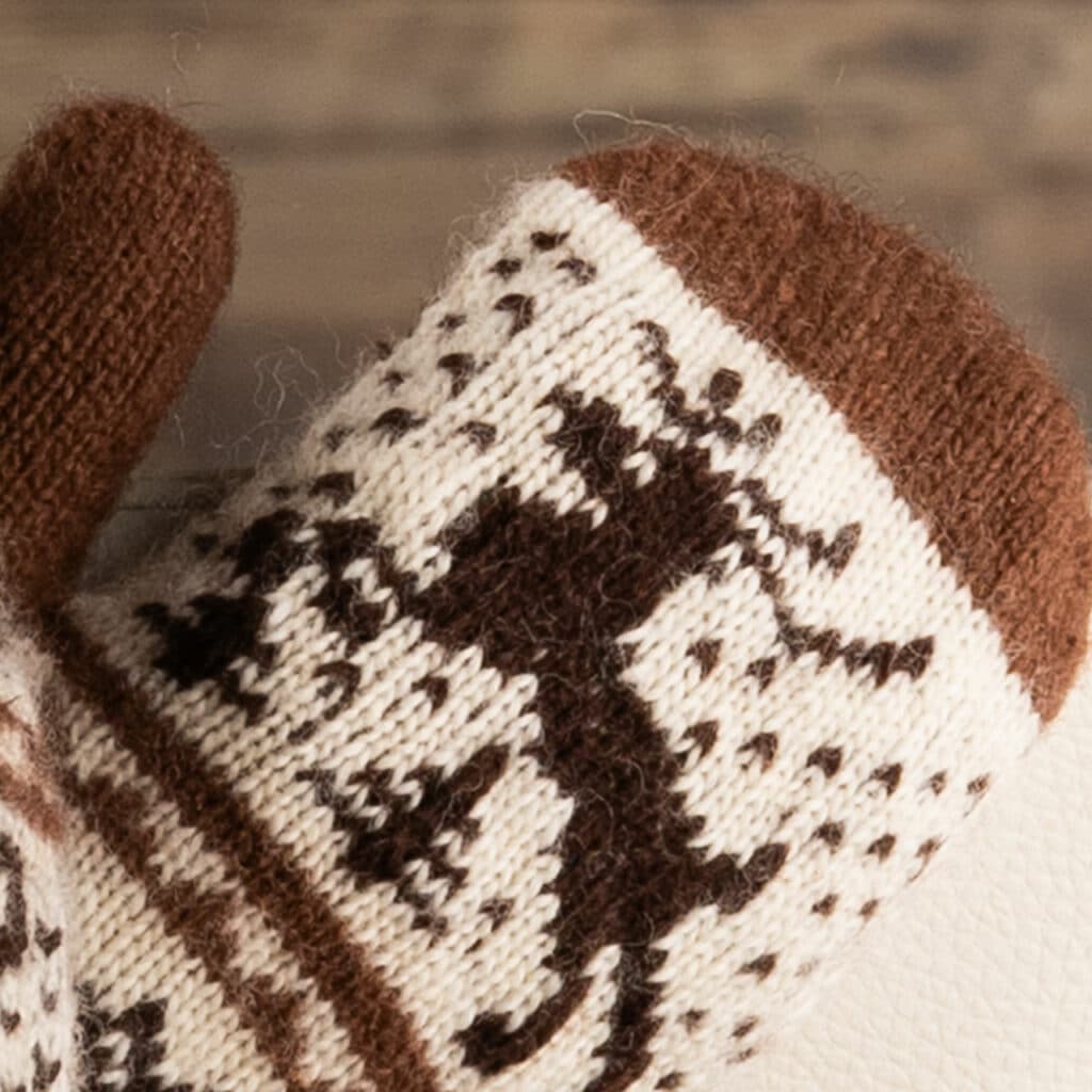 Warm wool mittens in dark brown and ecru, with cheerful deer motif.